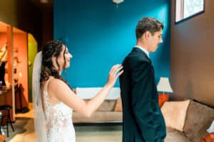 A bride and groom getting ready in a living room.