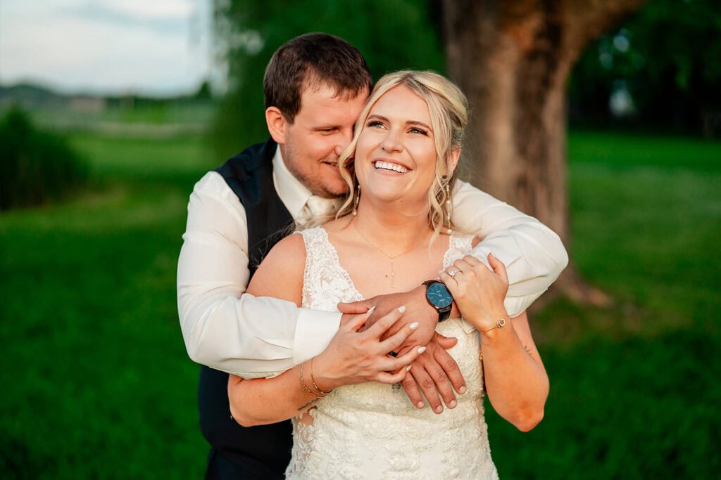 candid-bride-groom-sunset-embrace-maple-grove-events-west-salem.jpg Joyful bride and groom sharing a loving moment outdoors at Maple Grove Events during their wedding.