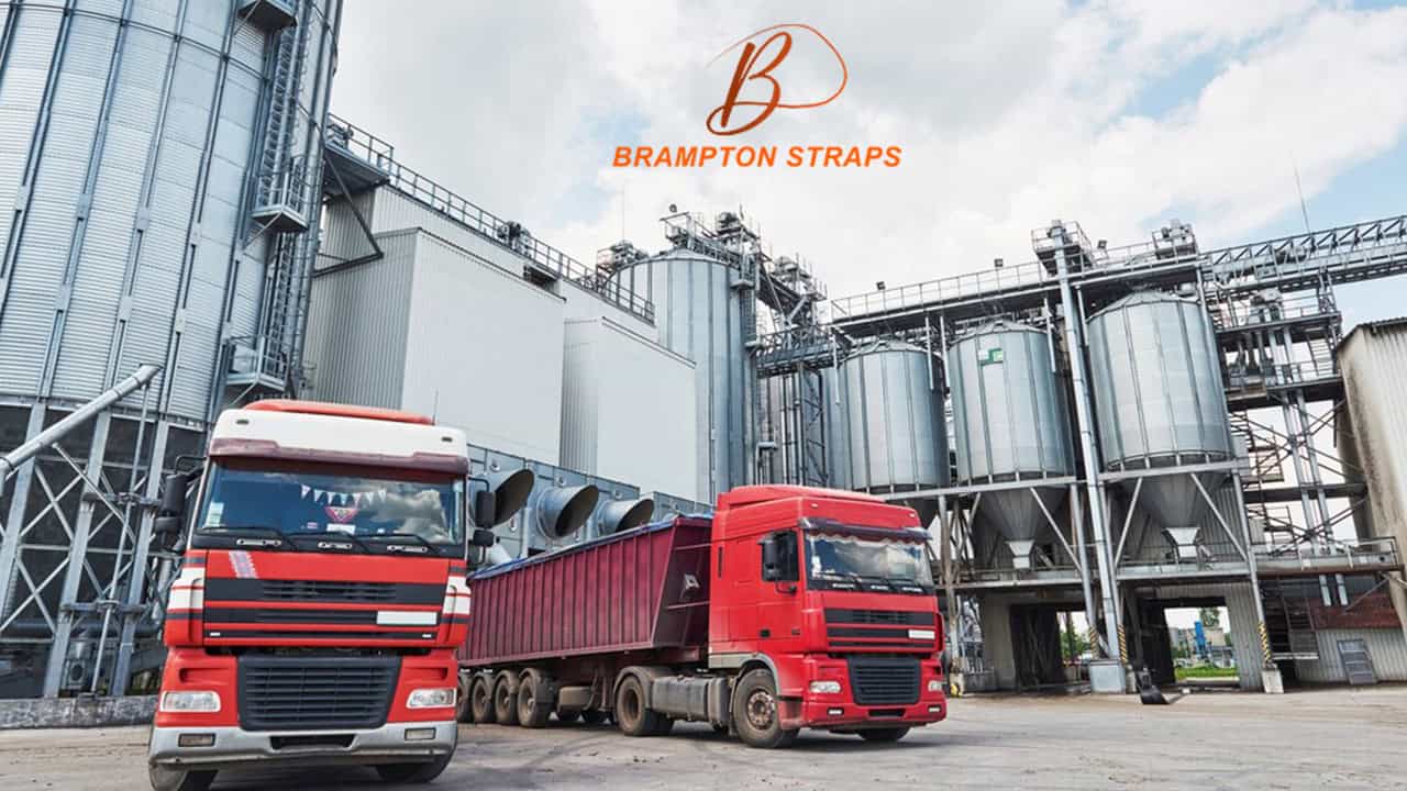 Industrial storage facility with red trucks and brampton straps signage for warehouse logistics and industrial safety.