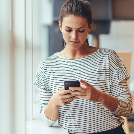 Vrouw op haar mobiele telefoon en leunt 600x600