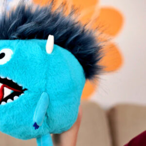 Mascot holding a plush toy dragon for breathing exercises and relaxation.