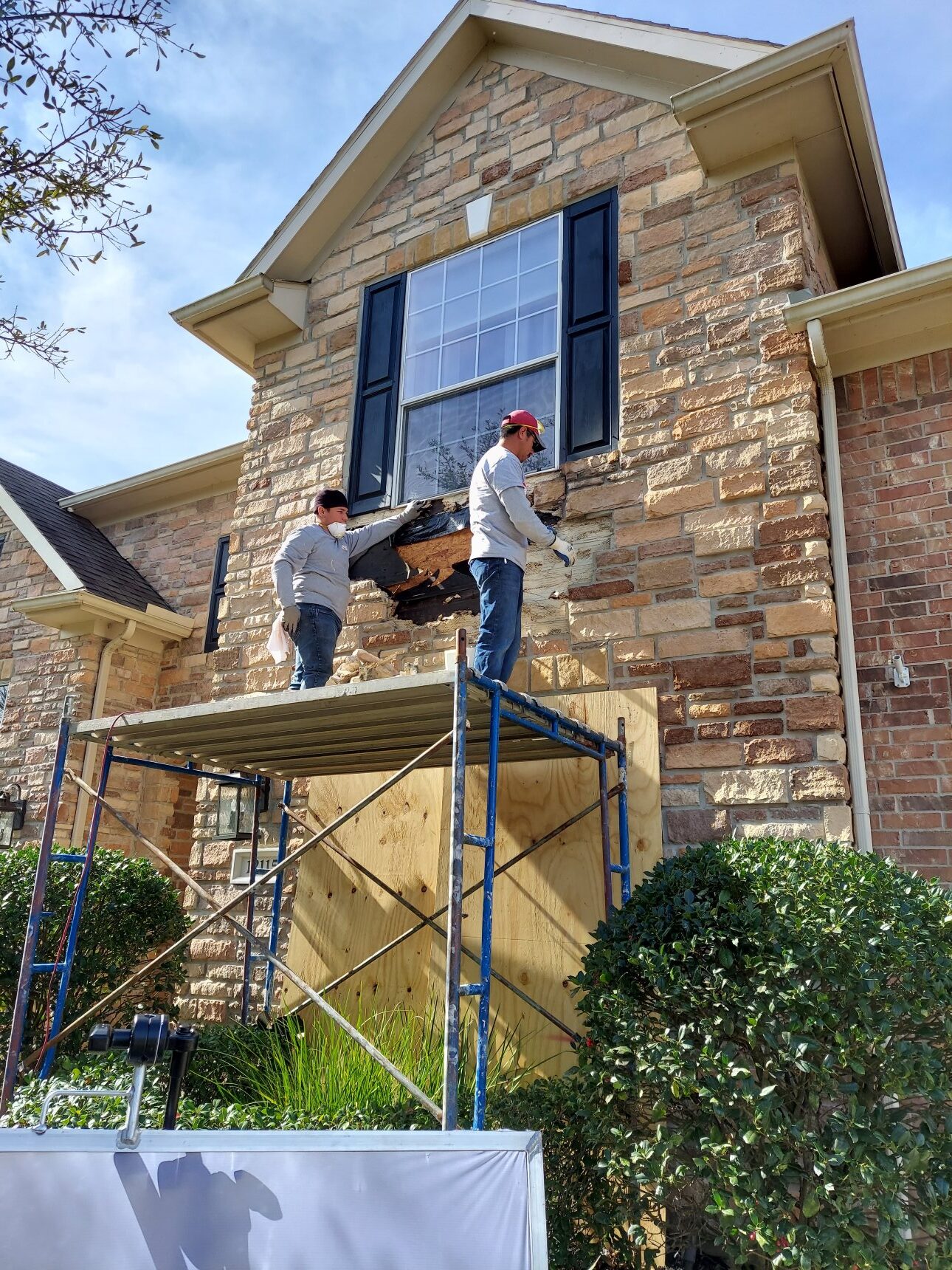 Masons Repairing Loose Stones on Home