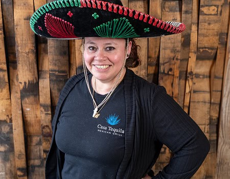 Woman wearing a colorful sombrero at Casa Tequila Mexican Grill & Cantina.