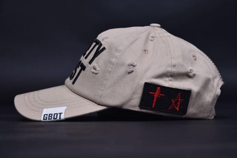 Beige streetwear cap with embroidered patches and distressed details.