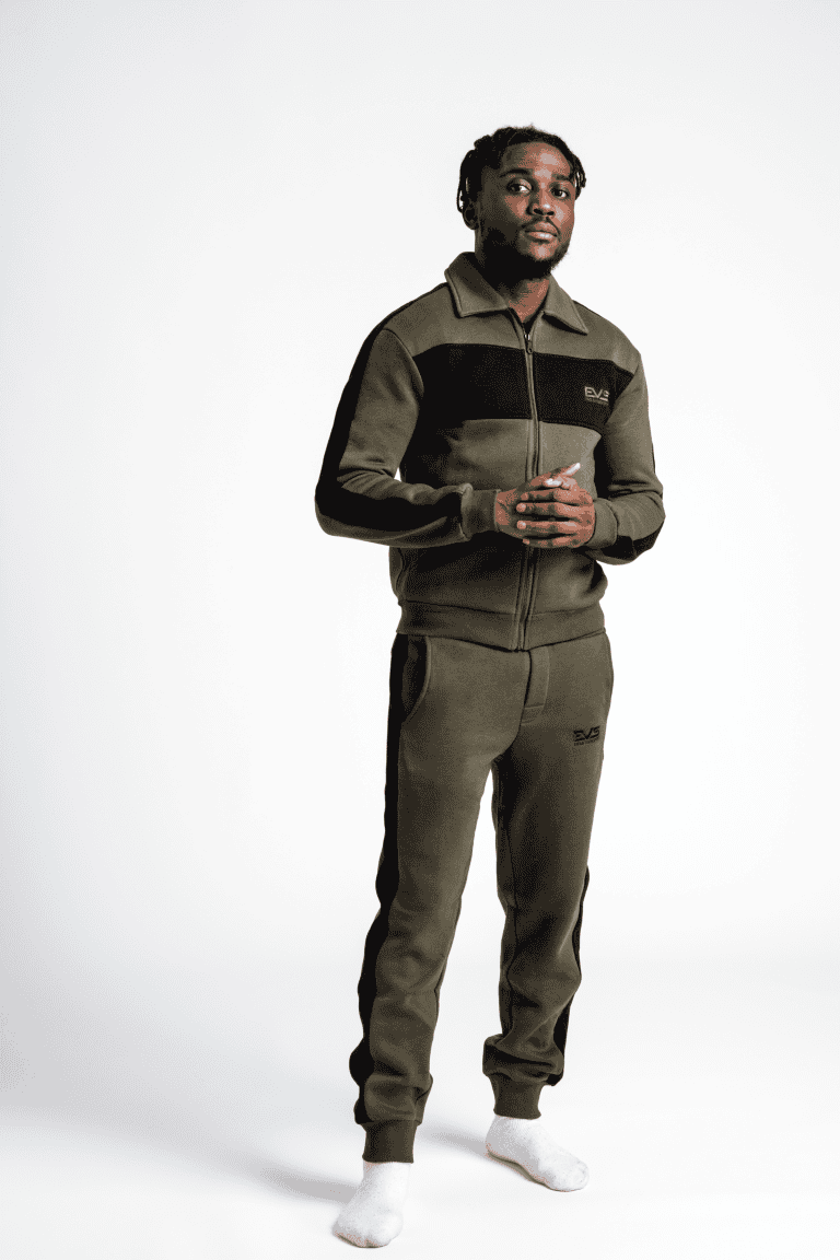 Man wearing olive green streetwear tracksuit with black accents.