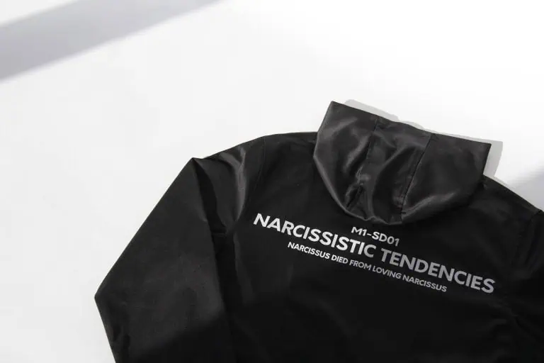 Black hoodie with "Narcissistic Tendencies" text and Narcissus quote, stylish streetwear.