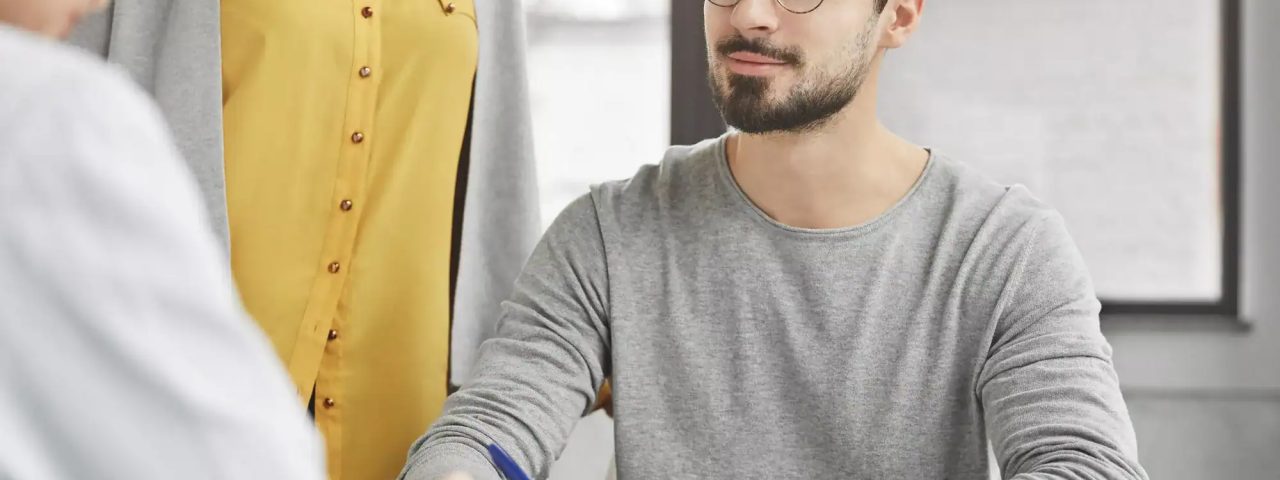 Bearded male employer communicates with job applicant, conducts interview with expert in economy fie