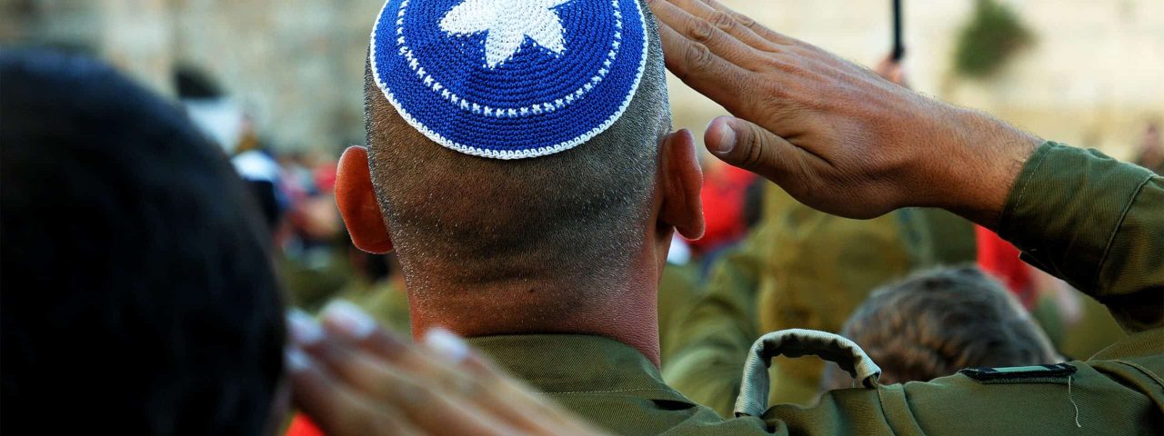 Israeli soldier military man saluting to the Western wall in Jerusalem