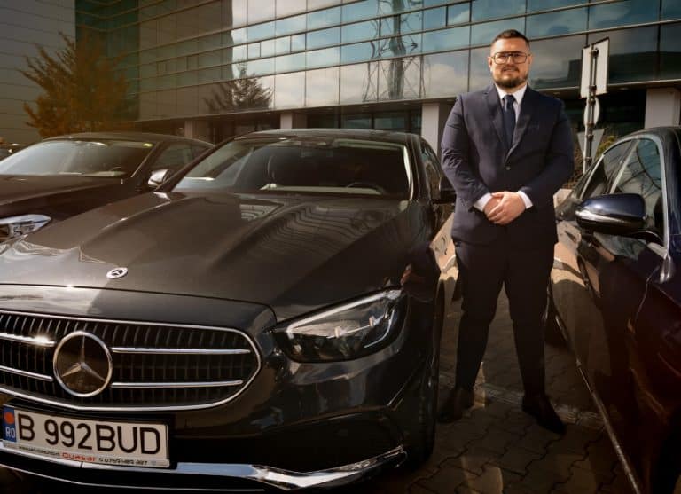 Professional chauffeur standing next to a Mercedes E-Class from the Bud’s Cab fleet in Bucharest