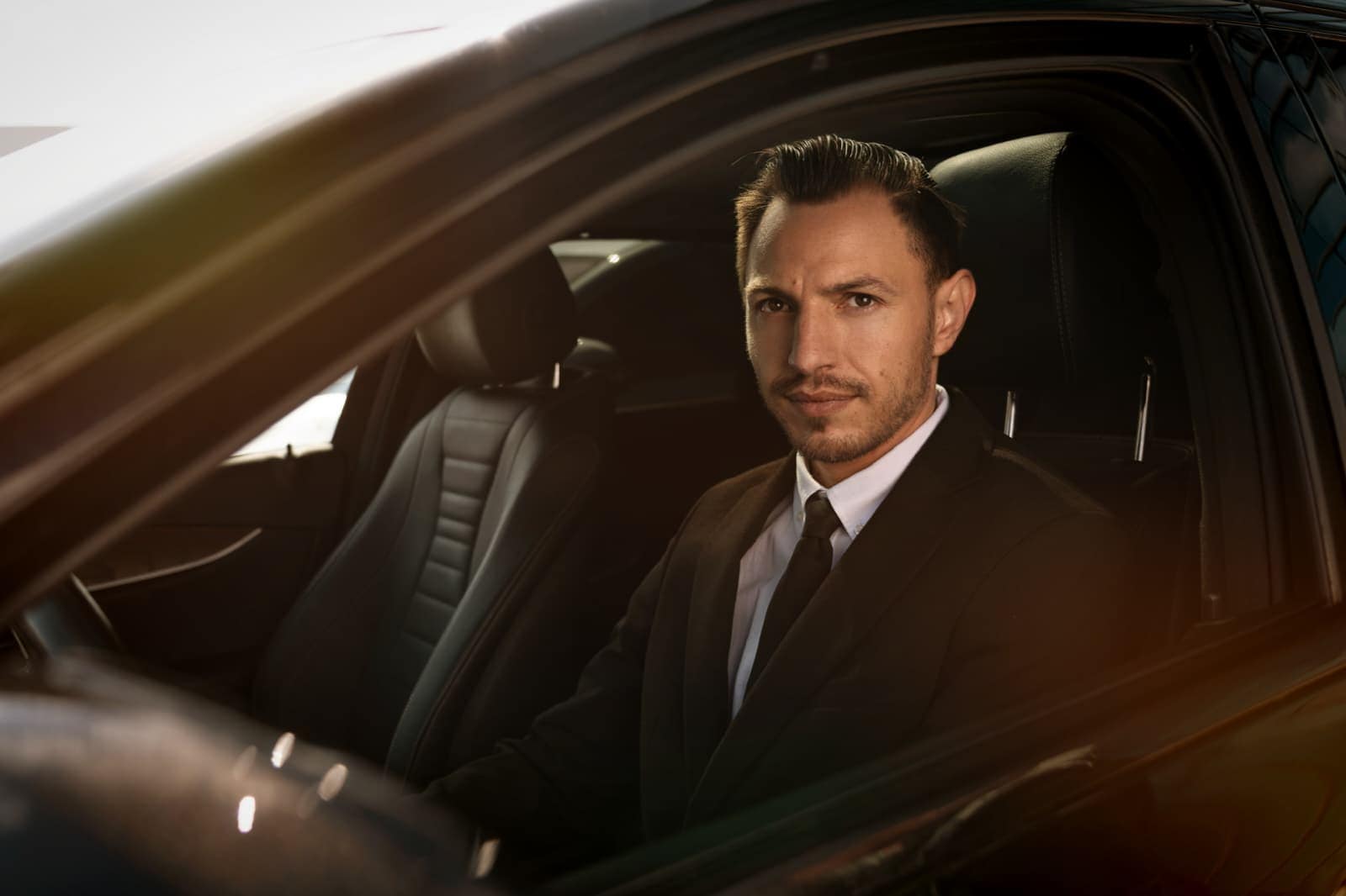 Professional Bud’s Cab chauffeur portrait inside a premium sedan in Bucharest
