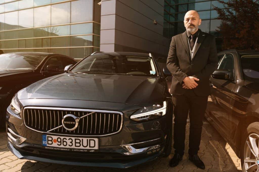 Professional chauffeur next to a Volvo S90 for premium business travel in Bucharest