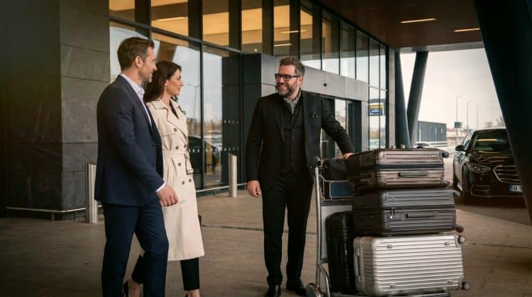 Professional chauffeur assisting passengers with luggage during a premium arrival transfer