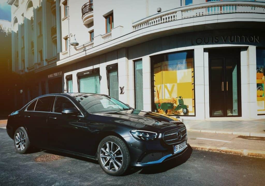Black Mercedes E-Class parked outside a luxury shopping destination in Bucharest