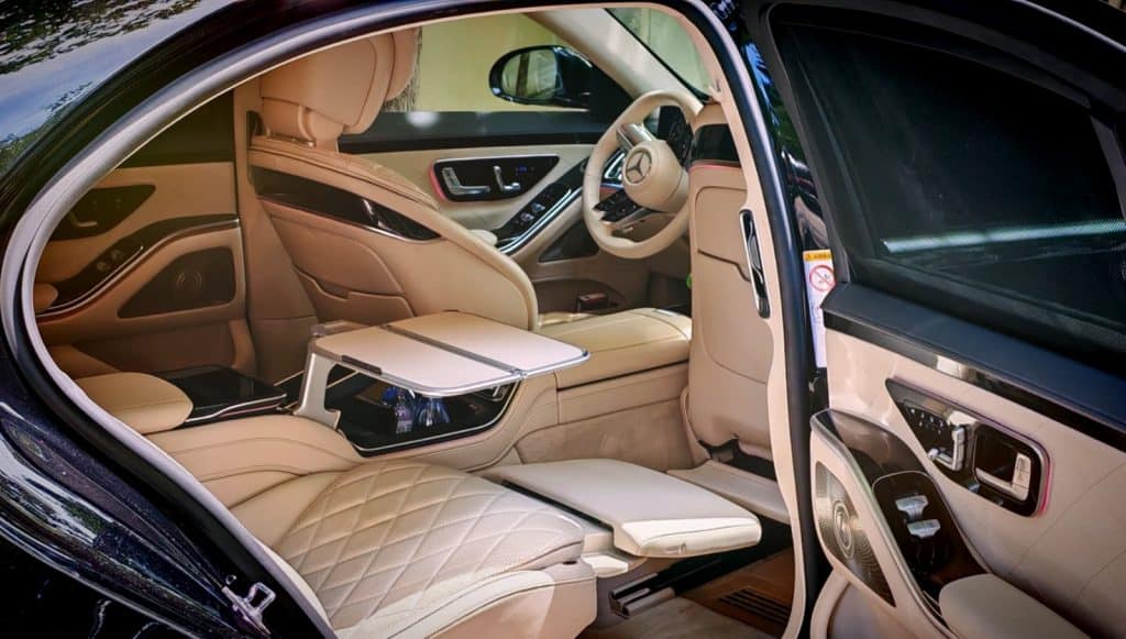 First-class rear cabin of a Mercedes S-Class with cream leather seats and executive comfort features