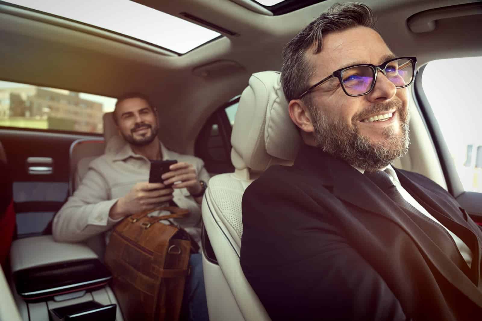 Professional chauffeur driving a premium sedan with passenger in the rear seat