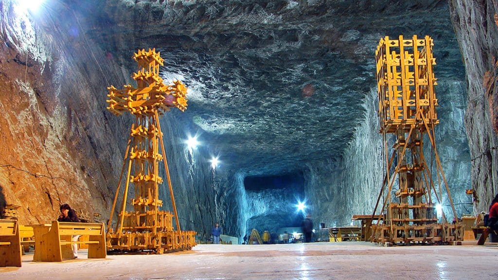 Underground mineral water cave with wooden structures and lighting.