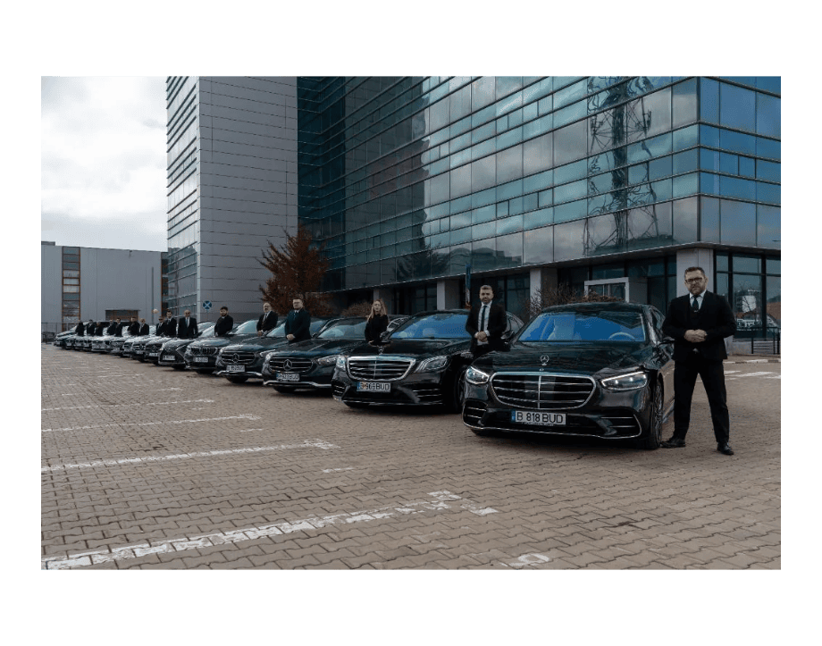 Fleet of luxury chauffeur cars with drivers outside modern office building.