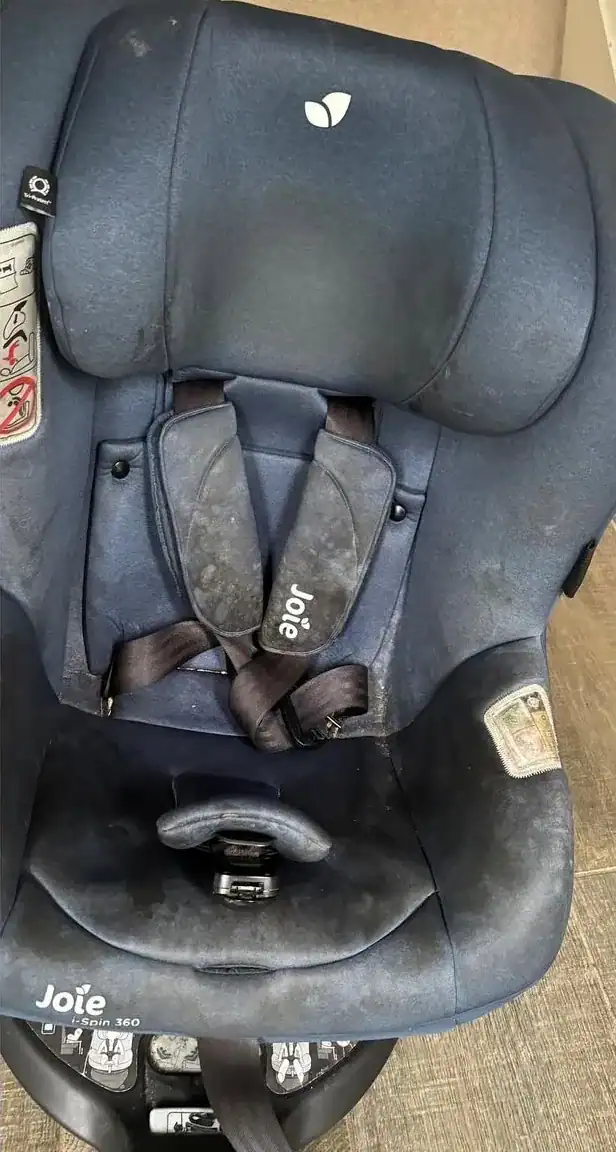 Dark blue child car seat with harness straps.