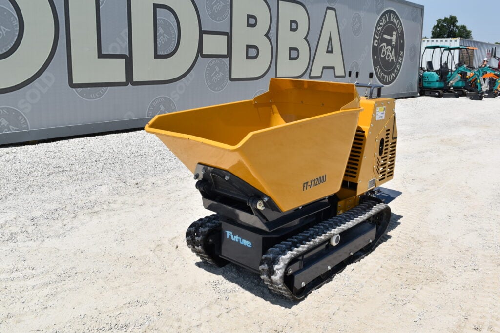 Yellow mini excavator with tracked base at auction site.