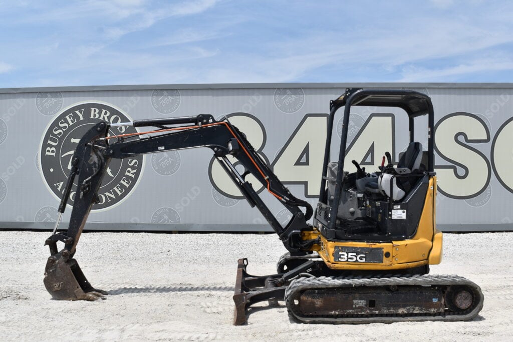 Yellow mini excavator with black arm at Bussey Bros Auctioneers.