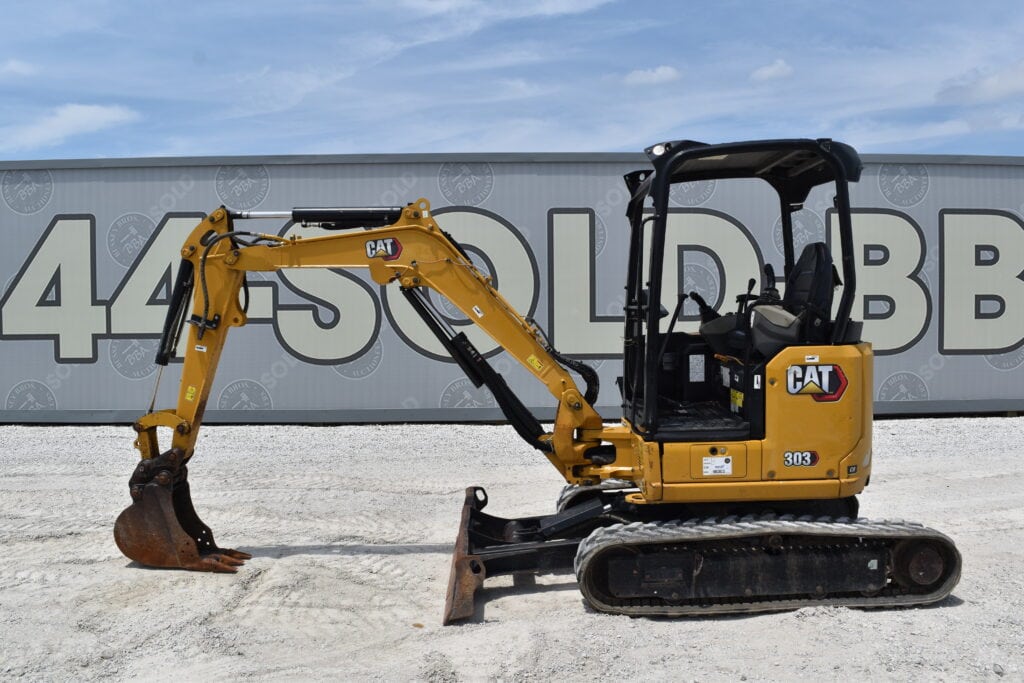 Yellow CAT mini excavator with black tracks at heavy equipment auction.
