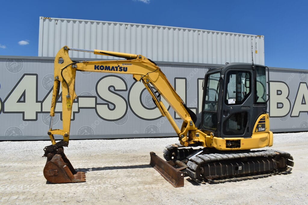 Yellow Komatsu mini excavator with bucket attachment on auction lot.