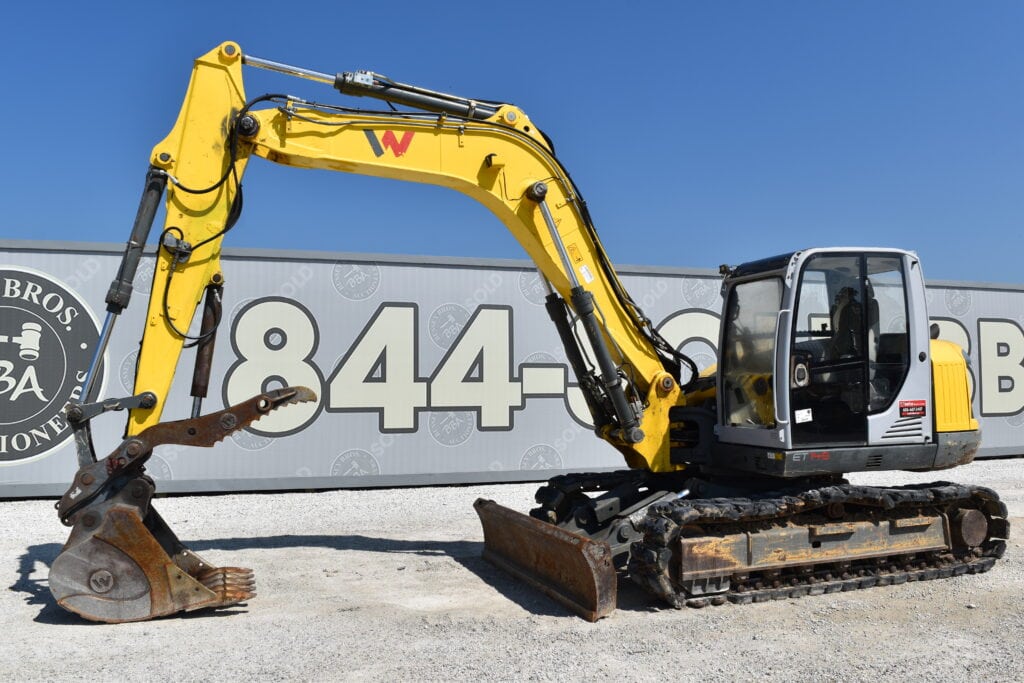Yellow excavator at Bussey Bros Auctioneers for heavy equipment sale.