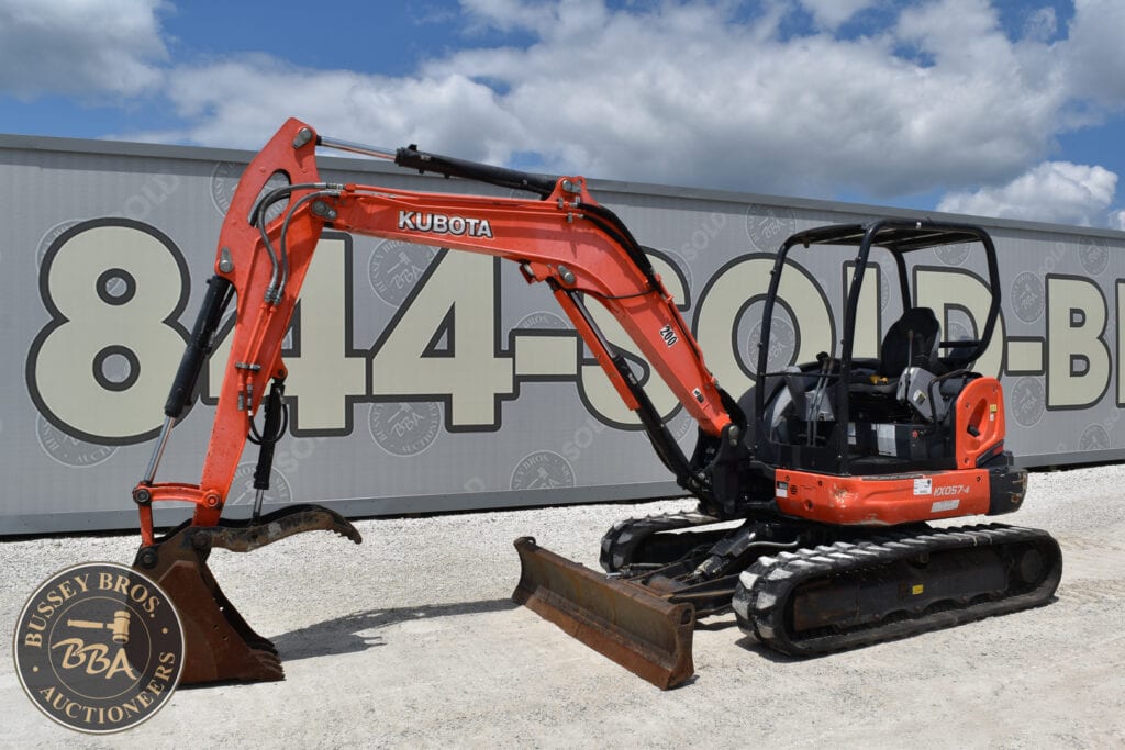 Orange Kubota mini excavator with bucket attachment on a gravel surface.