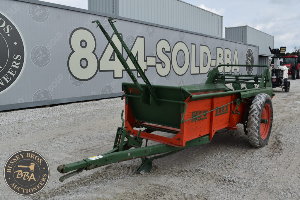 Green and orange agricultural trailer at Bussey Bros auction site.