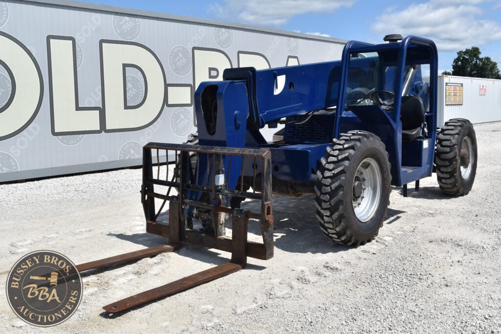 Blue forklift with extended forks at heavy equipment auction.