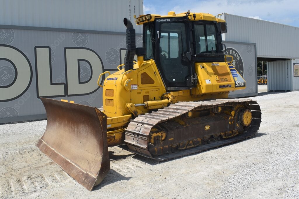 Yellow Komatsu bulldozer with blade and tracks at auction site.
