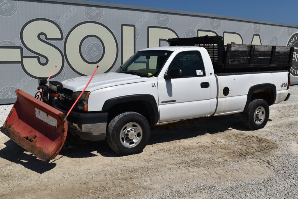 White pickup truck with snow plow at Bussey Bros Auctioneers.