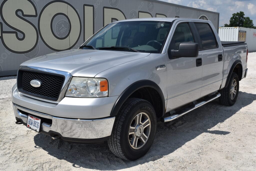 Silver Ford F-150 pickup truck at heavy equipment auction lot.