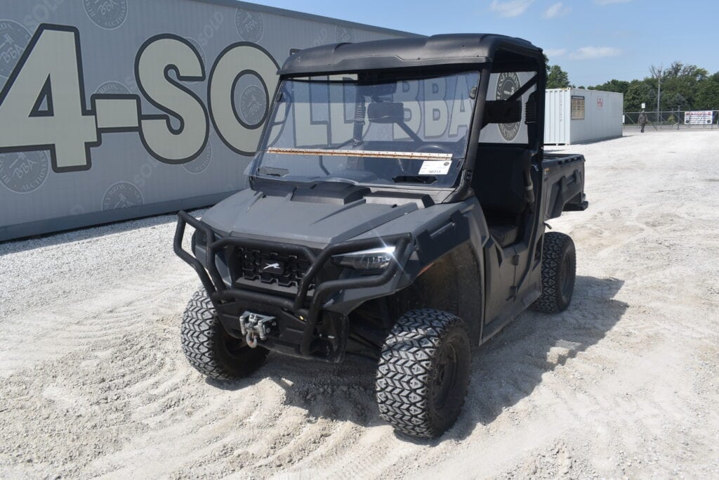 Black utility vehicle with rugged tires at heavy equipment auction.