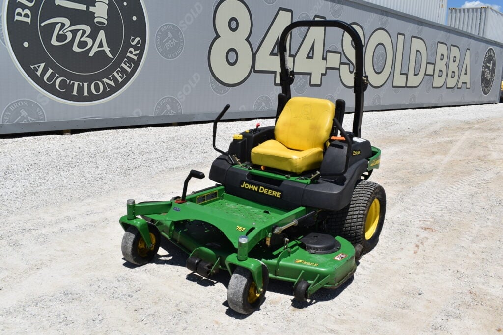 Green John Deere zero-turn mower with yellow seat for heavy equipment auction.