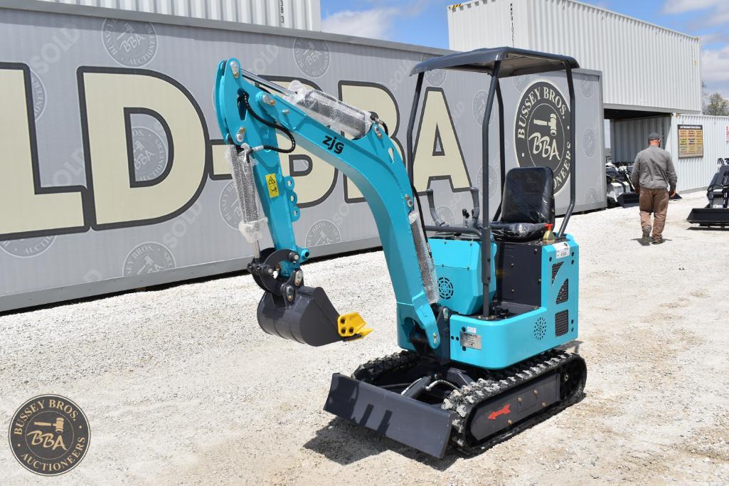 Mini excavator with blue body and tracked undercarriage, displayed outdoors at Bussey Bros Auctionee.