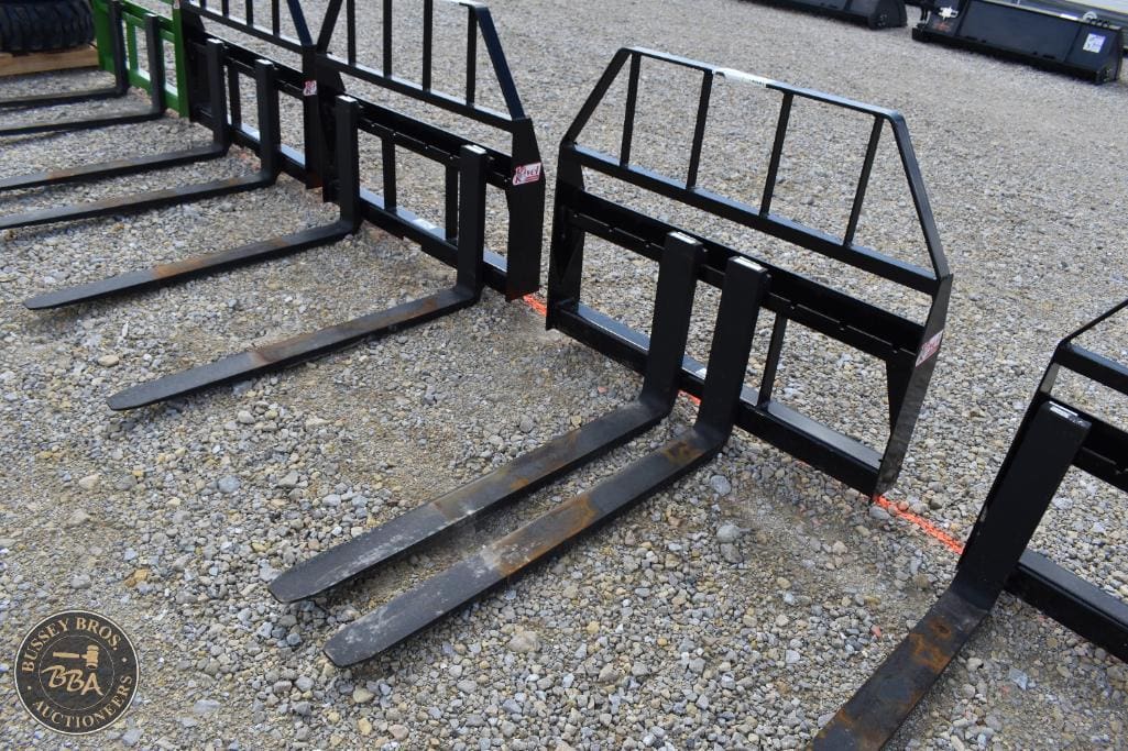 Forklift forks and safety frames displayed outdoors.