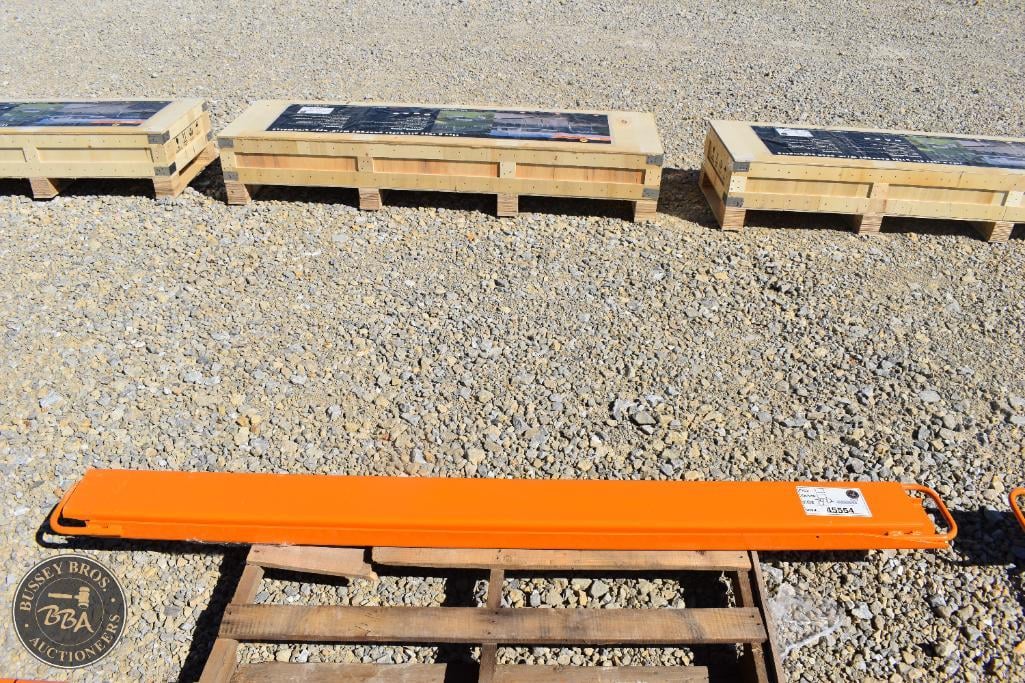 Orange measuring tool on wooden stand with auction boards in background.