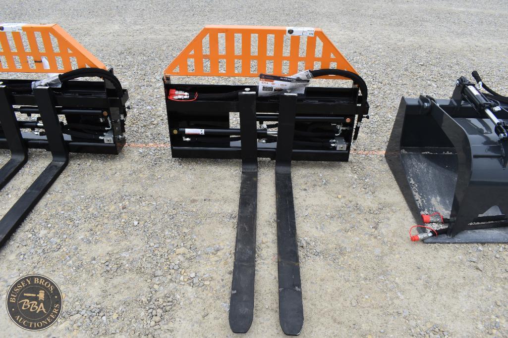 Heavy-duty forklift and skid steer attachments displayed outdoors.