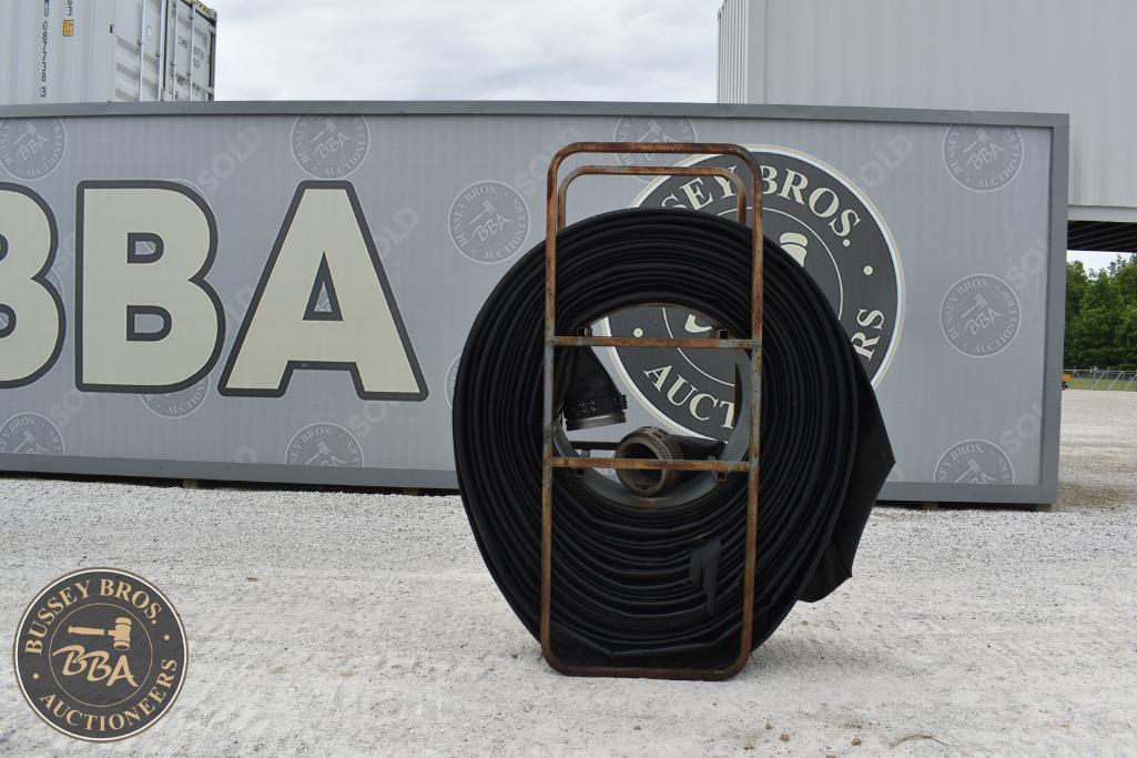 Large coiled black cable on a metal reel in front of Bussey Bros Auctioneers sign.