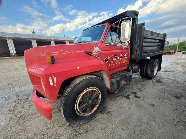 Red dump truck for sale at Bussey Bros Auctioneers, ideal for construction and hauling.