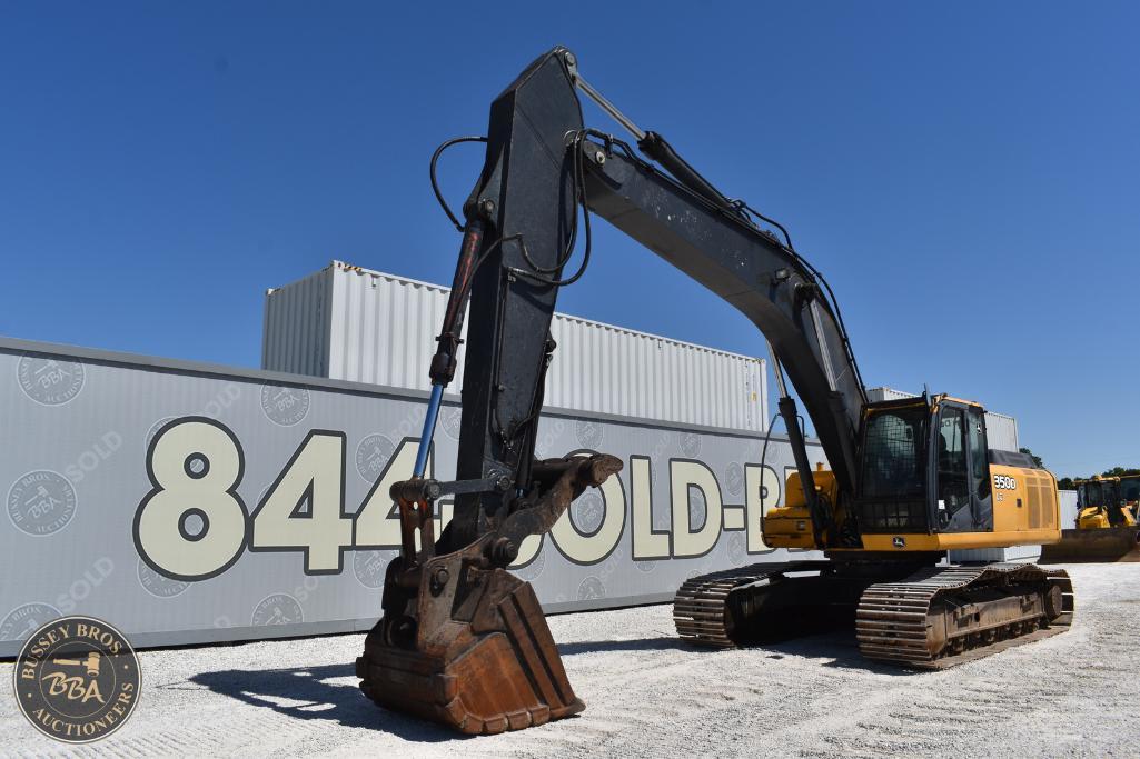 Excavator at Bussey Bros Auctioneers yard under clear blue sky.