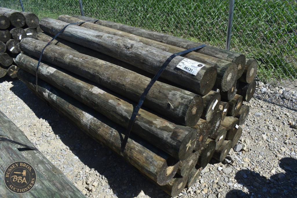 Stacked wooden logs for sale at Bussey Bros Auctioneers.
