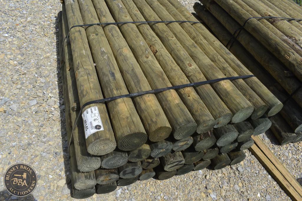 Wooden fence posts stacked for auction at Bussey Bros Auctioneers.