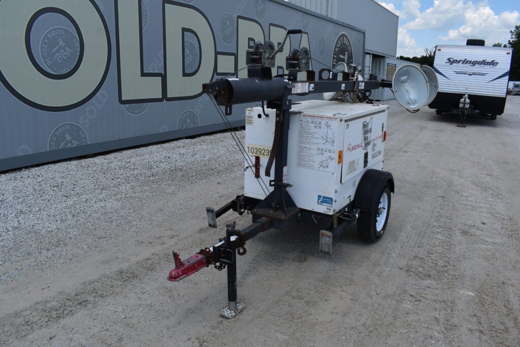 Portable light tower with generator and mast for construction sites.