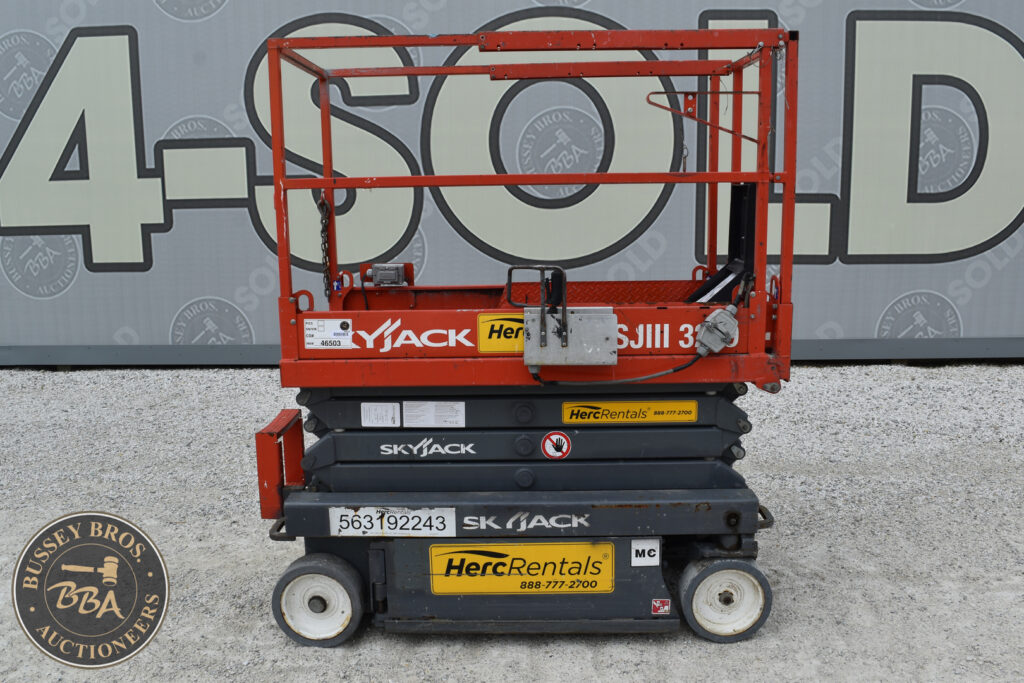 Red and black scissor lift for sale at auction event.