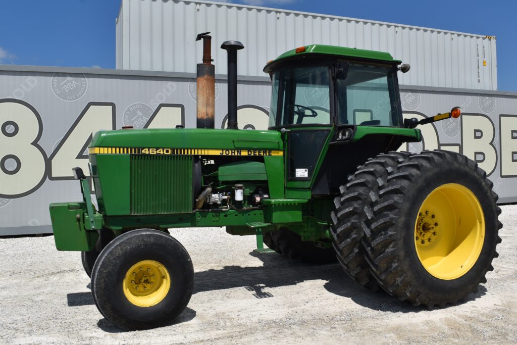 Green John Deere 4640 tractor with large rear tires at auction site.