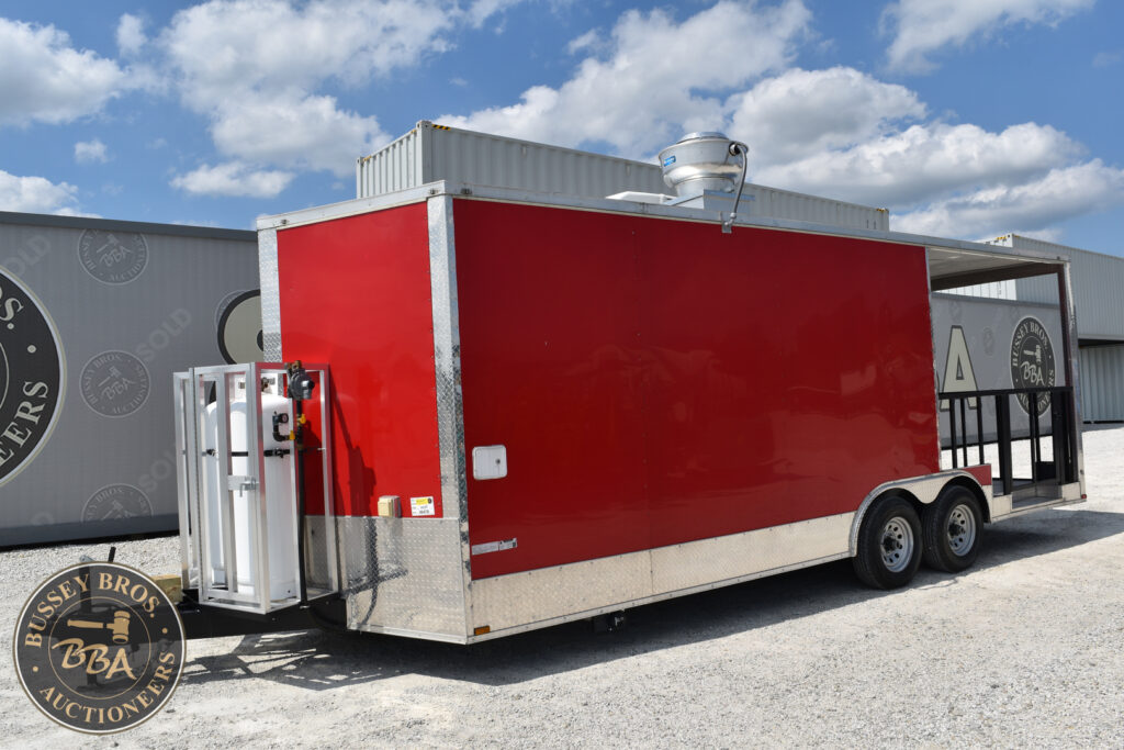 Red mobile auction trailer at Bussey Bros Auctioneers event.
