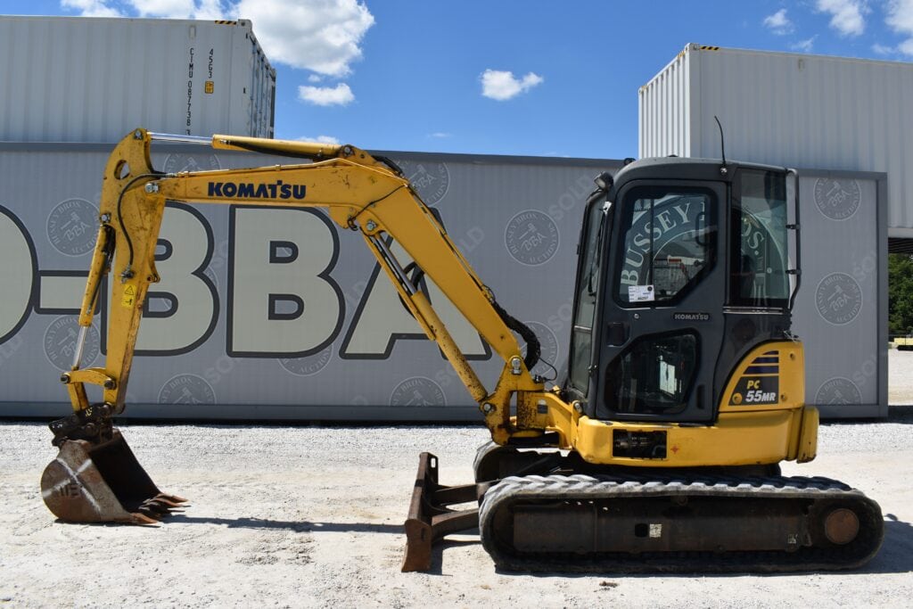 Yellow Komatsu mini excavator with black tracks at auction site.