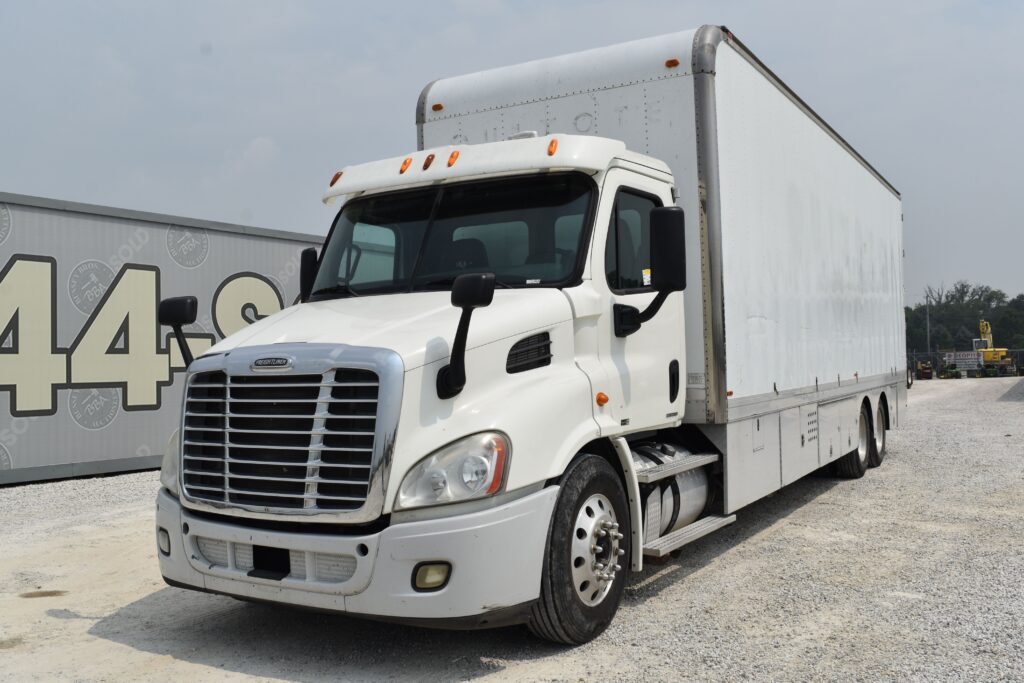 White freight truck at Bussey Bros Auction with large cargo box.
